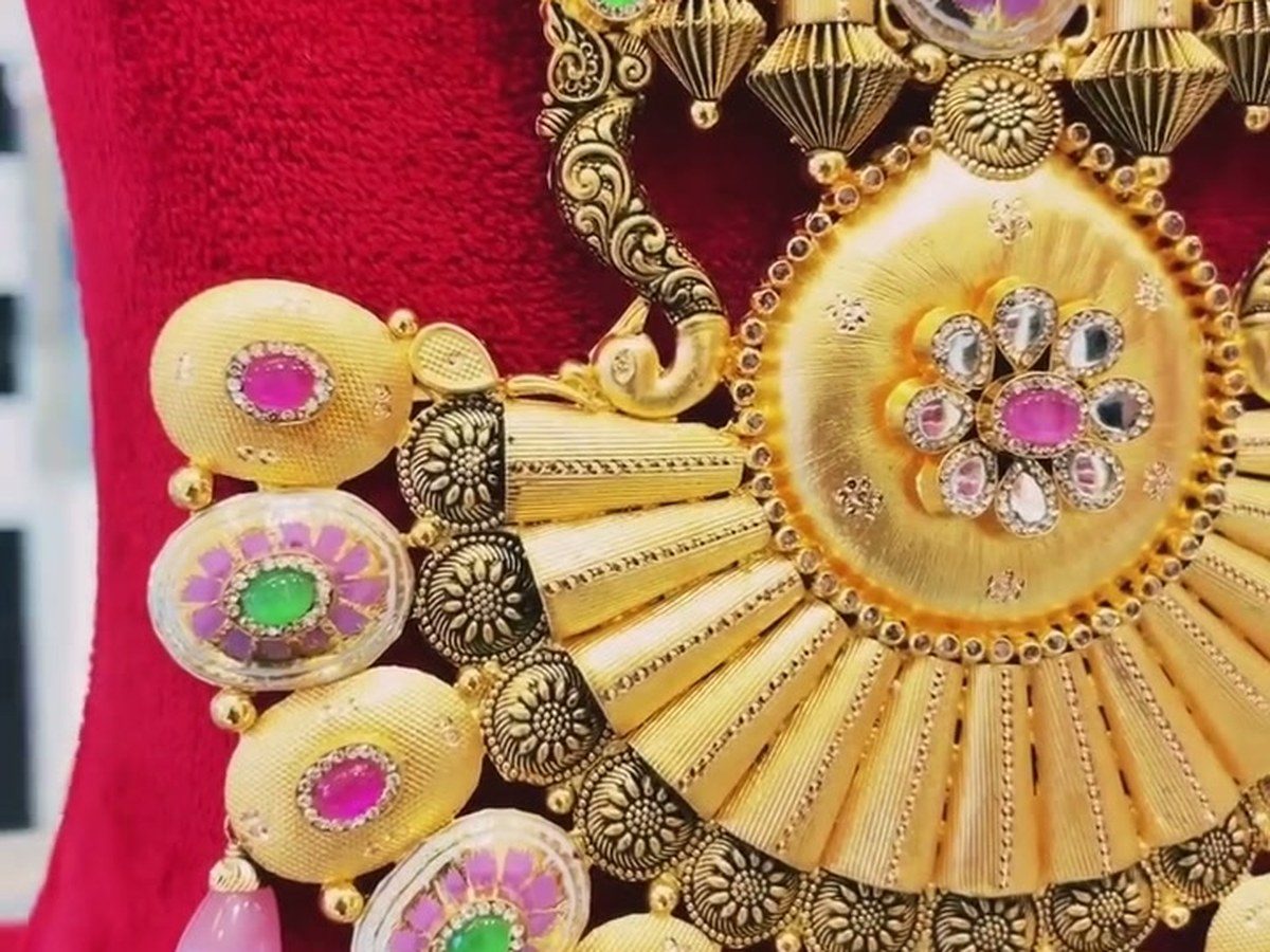 Close-up of heavy meenakari bridal gold work with pink and green stones